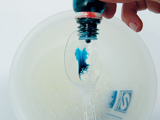 Acrescente a água deionizada e mexa. Pingue o corante azul e misture com a colher.