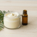 Condicionador natural de cipreste cremoso num pote com ramo de cipreste e oleo de argan ao lado