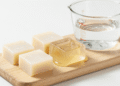 Cubos de base de glicerina transparente e branca sobre tabua de madeira