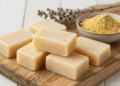 Sabonetes artesanais de enxofre em tom amarelo claro sobre tabua de madeira rustica