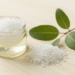 Esfoliante de sal grosso com tea tree para os pes num pote com sal grosso e ramo de melaleuca ao lado