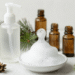 Frasco espumador liberando espuma de limpeza facial natural com ramo de pinho e oleos essenciais