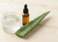 Gel de limpeza facial caseiro transparente num potinho com folha de babosa e oleo de argan ao lado