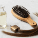 Frasco de glicerina vegetal ao lado de escova de madeira e mecha de cabelo saudavel