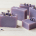 Sabonetes artesanais de lavanda lilas com botoes de lavanda secos e ramos frescos ao lado