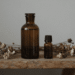 Frasco ambar de perfume artesanal em maceracao com flores secas e oleos essenciais
