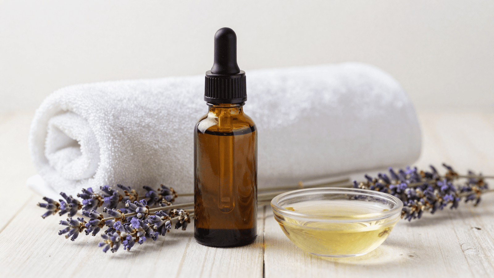 Oleo de massagem aromaterapico pronto em frasco conta-gotas num cenario de spa com lavanda