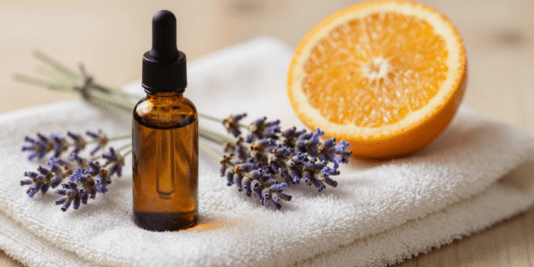Oleo de massagem aromaterapico em frasco conta-gotas com lavanda e laranja numa toalha de spa