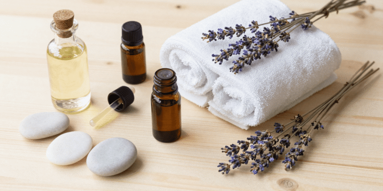 Materiais de aromaterapia para massagem nos pes: oleo, toalha, oleos essenciais e lavanda