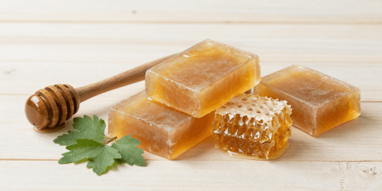Sabonetes de propolis e confrei cor de mel com favo de mel e folhas de confrei ao lado