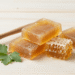 Sabonetes de propolis e confrei cor de mel com favo de mel e folhas de confrei ao lado