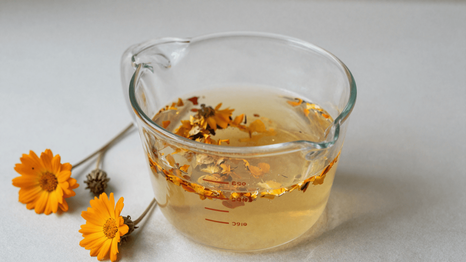 Derretendo a base de glicerina vegetal e misturando petalas de calendula desidratadas