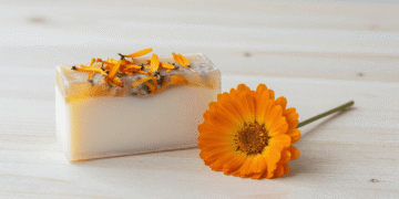 Sabonete vegetal de calendula em duas camadas com petalas suspensas e flores de calendula