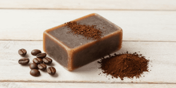 Sabonete esfoliante de cafe artesanal com cafe em po e graos de cafe ao lado
