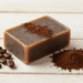 Sabonete esfoliante de cafe artesanal com cafe em po e graos de cafe ao lado