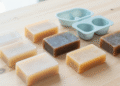 Sabonetes caseiros simples transparentes e coloridos com formas de silicone ao lado