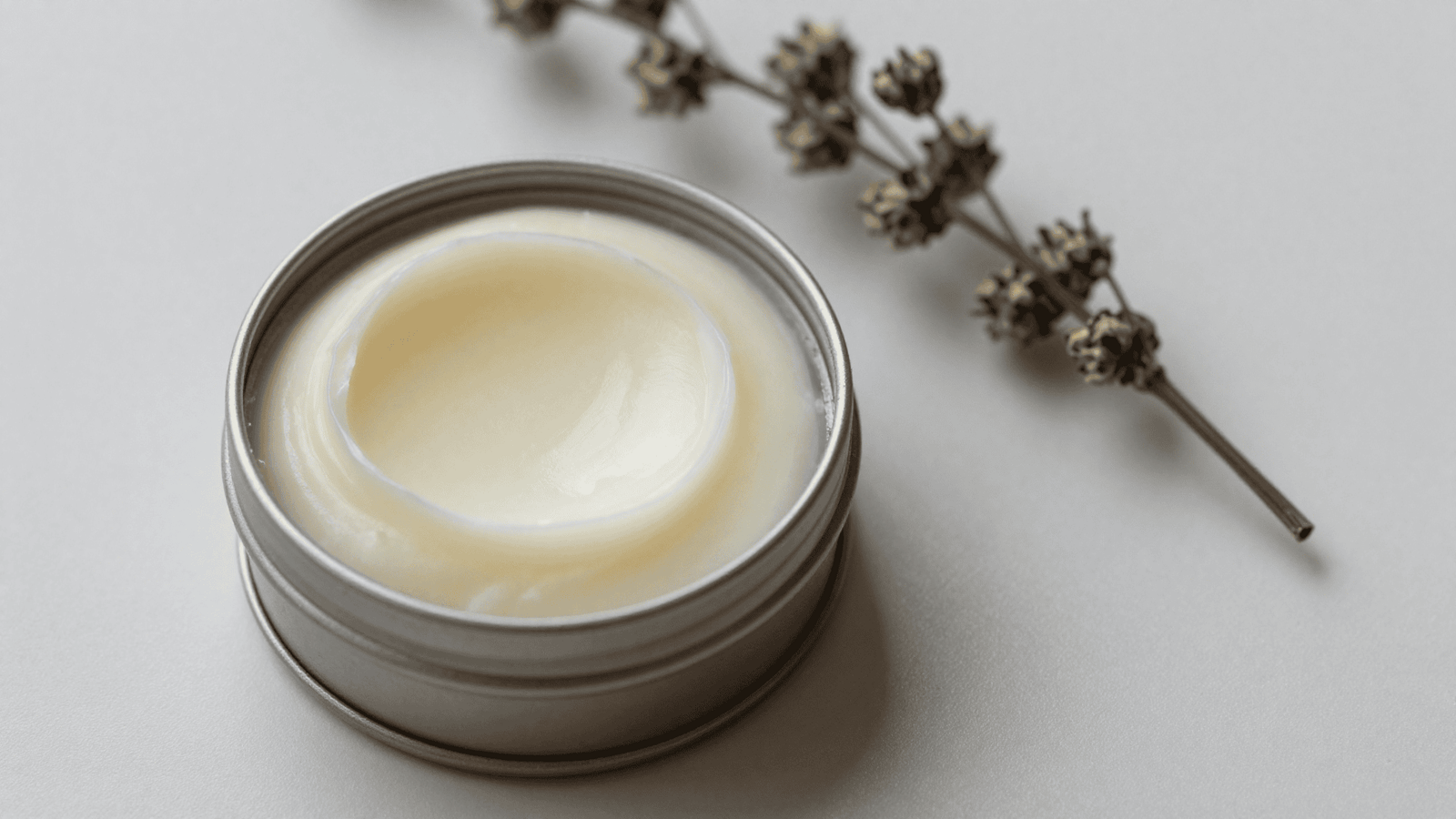 Lip balm cremoso pronto em uma latinha aberta sobre a mesa clara