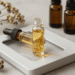 Frasco roll-on de perfume em óleo sobre mesa clara com flores secas e frascos de óleo essencial