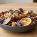 Tigela decorativa com pot-pourri colorido de flores secas, folhas, rodelas de cítrico e canela