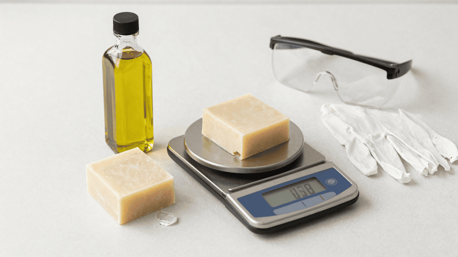 Óleo de coco, azeite, balança e óculos e luvas de segurança para fazer sabonete natural